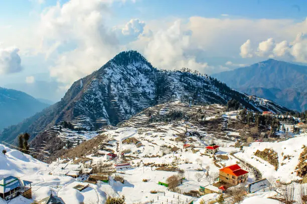 Fresh snow covering mountain peaks and pine forests in a high valley